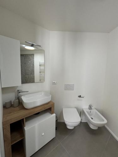 a bathroom with a sink and a toilet and a mirror at Il Giardino Segreto in Faggeto Lario 