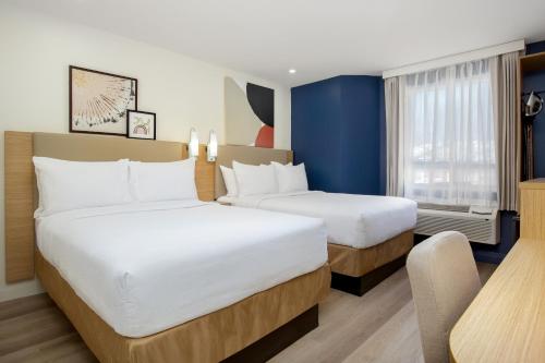 a hotel room with two beds and a window at Spark by Hilton Brockville in Brockville
