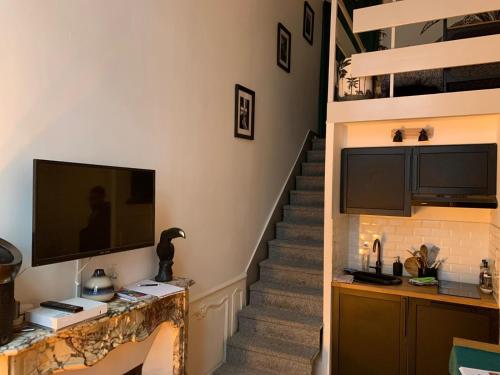 a living room with a staircase and a television at Centre historique, appartement cosy in Avignon