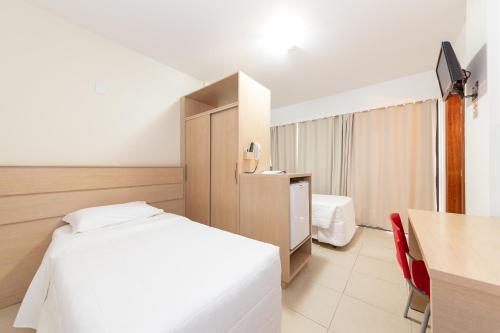 a hotel room with a bed and a table and a desk at Slim São José Zion in São José
