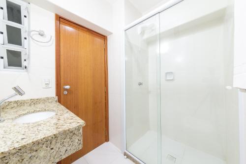 a bathroom with a sink and a shower at Slim São José Zion in São José