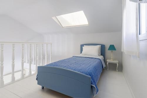 a bedroom with a bed with a blue comforter at Belvedere Skopelos in Neo Klima
