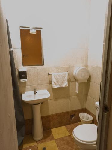 a small bathroom with a sink and a toilet at Loki Cusco in Cusco