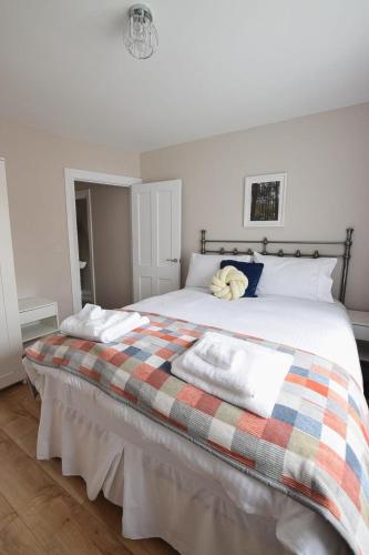 a bedroom with a large bed with a plaid blanket at Maggies Leap Townhouse in Newcastle