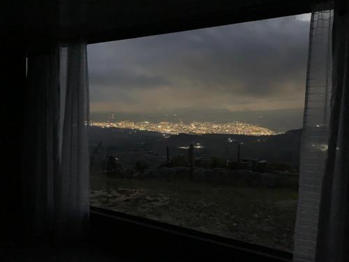 a window with a view of a city at night at Cabaña La Conquista in Chivatá