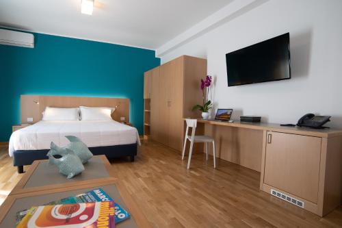 a bedroom with a bed and a desk with a tv at AWA Kafara in Porticello