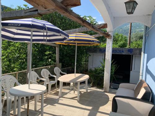 two tables and chairs with umbrellas on a patio at Galicia Hills in Becici