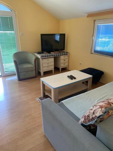 a living room with a couch and a table and a tv at Galicia Hills in Becici
