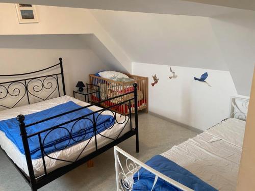 a bedroom with two beds and a crib at Gîte du Chatelet in Tardinghen