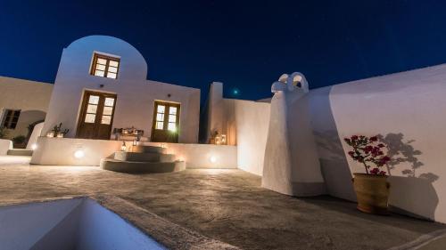 a white building with a courtyard at night at Athinais Mansion in Megalokhori