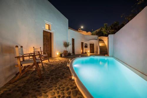 a swimming pool in front of a house at night at Athinais Mansion in Megalokhori