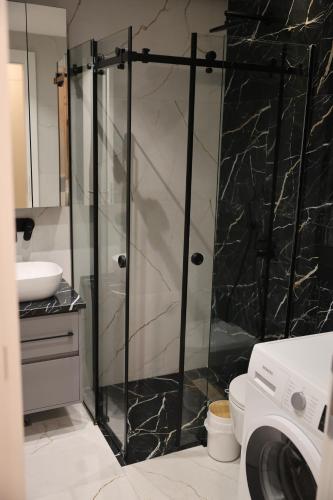 a glass shower door in a bathroom with a toilet at Apartment Story Nis in Niš