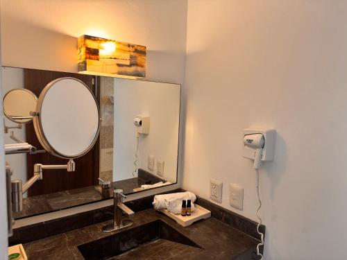 a bathroom with a sink and a mirror at Hotel TamYanJa in Tamiahua