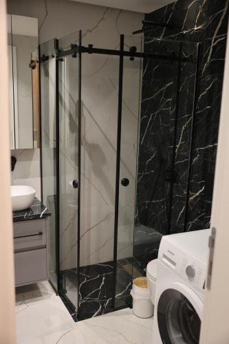 a bathroom with a shower with a glass door at Apartment Story Nis in Niš
