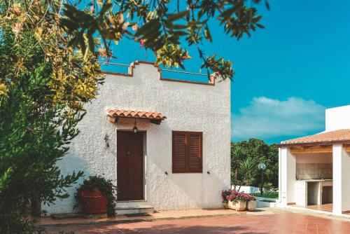 a white house with a door and a tree at Villa Lucia in Alghero