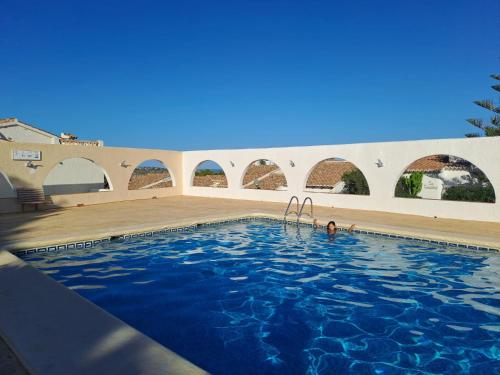 a person swimming in a swimming pool at Casa Lima Mediterránea in Benitachell