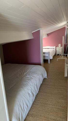 - une chambre avec un lit et un mur violet dans l'établissement Romarins, à Balaruc-les-Bains
