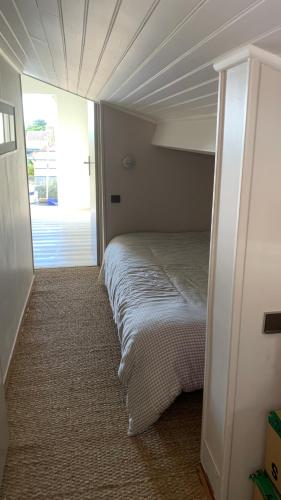 - une chambre avec un lit dans une pièce avec une porte dans l'établissement Romarins, à Balaruc-les-Bains