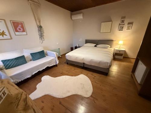 a room with two beds and a couch in it at En Kanalion well in Kanália
