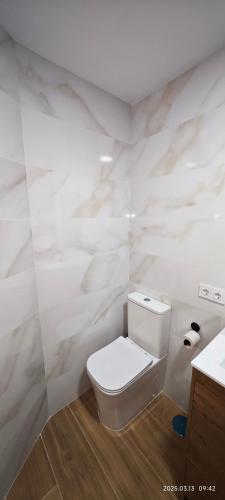 Un baño blanco con inodoro y lavabo. en JEREZ CENTRO 5 DORMITORIOS TERRAZAS CON VISTAS ALCAZAR Y PLAZA ARENAL, en Jerez de la Frontera