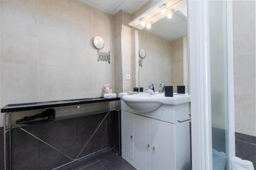 une salle de bain avec un lavabo et un miroir dans l'établissement Les Floralies, large 3-room, sea and Monaco view, à Roquebrune-Cap-Martin