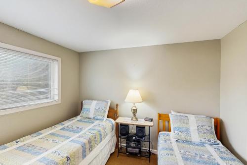 a bedroom with two beds and a table with a lamp at Bayview Escape in Lincoln City