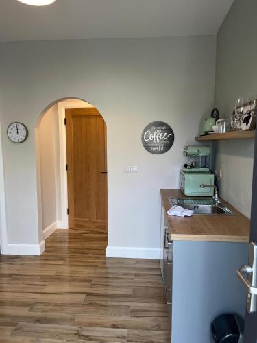 a kitchen with a counter and a sink and a door at Emville Lodge in Galway