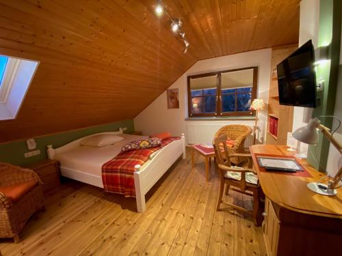 a bedroom with a bed and a desk in a room at Schumacher's Landhaus - Bücherhotel in Friedeburg