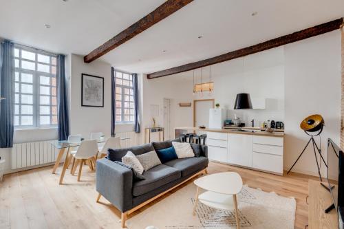 un salon avec un canapé et une table dans l'établissement Hypercentre, cosy et typique, wifi, à Toulouse