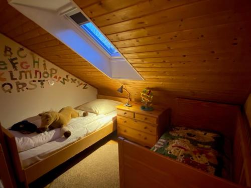 a bedroom with a bed with a teddy bear on it at Schumacher's Landhaus - Bücherhotel in Friedeburg
