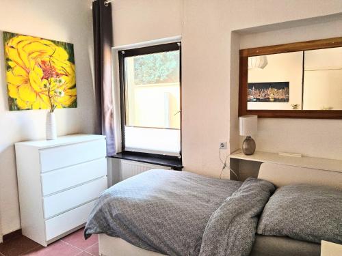 a bedroom with a bed and a dresser and a window at Casa Gia EG in Remagen