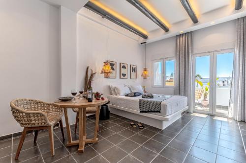 a bedroom with a bed and a table and chairs at Flèria Seaview Suites in Naxos Chora