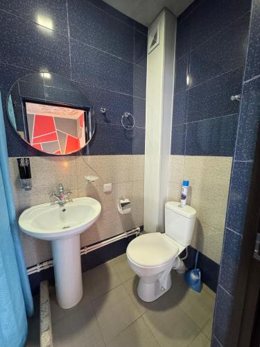 a bathroom with a sink and a toilet and a mirror at Paxlava Dilijan Guesthouse & Restaurant in Dilijan
