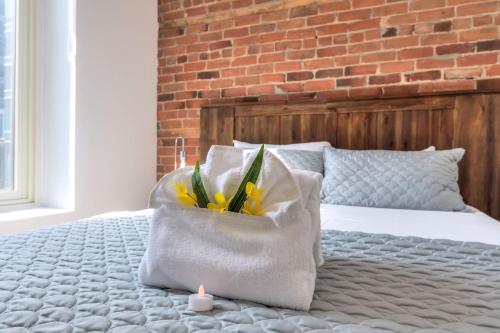 Una cama con una almohada con flores amarillas en una bolsa en Fox Aparthotel Palais Des Congres IV, en Montreal