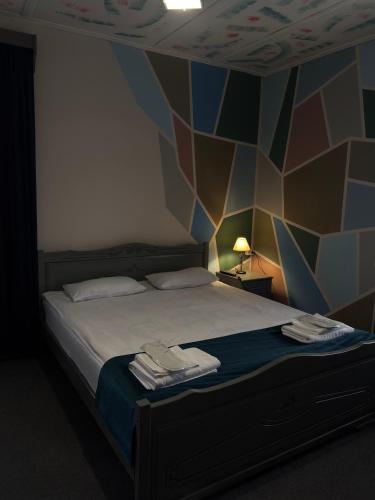 a bedroom with a bed with a geometric wall at Paxlava Dilijan Guesthouse & Restaurant in Dilijan