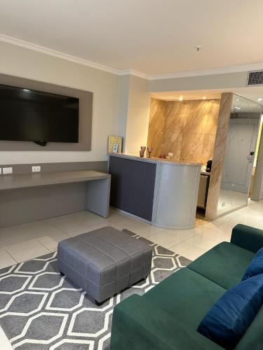 a living room with a flat screen tv and a couch at Hotel Saint Paul in Sao Jose do Rio Preto