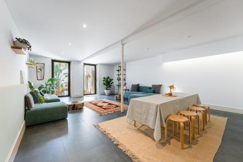 a living room with a table and a green couch at Hidden Gem near city center- garden, outdoor kitchen, sauna in Porto