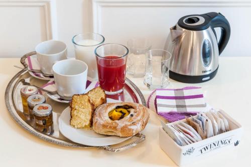 - une table avec un plateau de produits pour le petit-déjeuner et du café dans l'établissement Navona Central Suites, à Rome