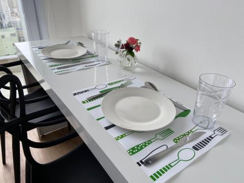 a white table with plates and cutlery on it at 360 Suítes Sé in Sao Paulo