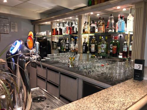 a bar with glasses on a counter with alcohol at L'embellie in Treffort