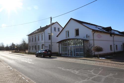 a car parked in front of a white building on a street at Gut Kuhfs in Großzössen