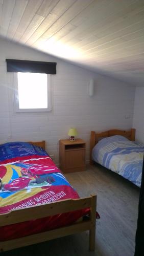 une chambre avec deux lits et une fenêtre dans l'établissement CHALET Soulac Sur MER, à Soulac-sur-Mer