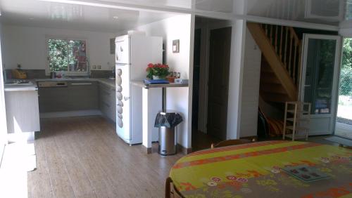une cuisine avec un réfrigérateur blanc et un escalier dans l'établissement CHALET Soulac Sur MER, à Soulac-sur-Mer