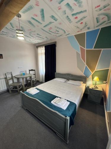 a bedroom with a bed with a painted ceiling at Paxlava Dilijan Guesthouse & Restaurant in Dilijan