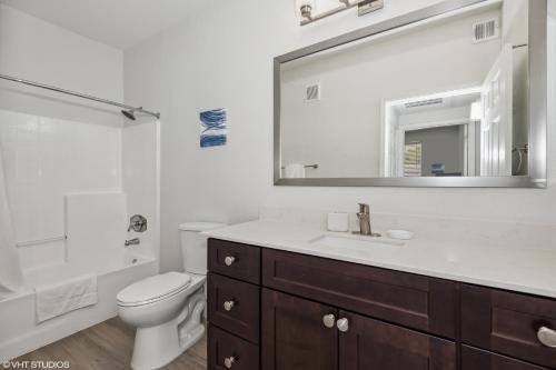 un bagno con lavandino, WC e specchio di Pure Suites Glendale Furnished Two Bed Pool Gym a Glendale