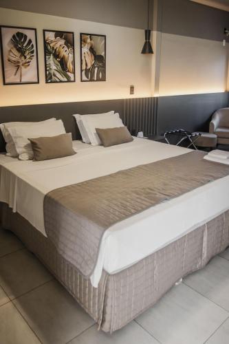 a large bed in a hotel room with a large bedvisor at Avenida Hotel in Sorriso