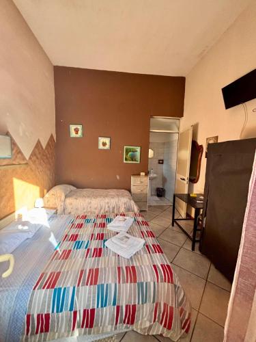 a hotel room with two beds and a television at Guest house in Acireale in Santa Tecla
