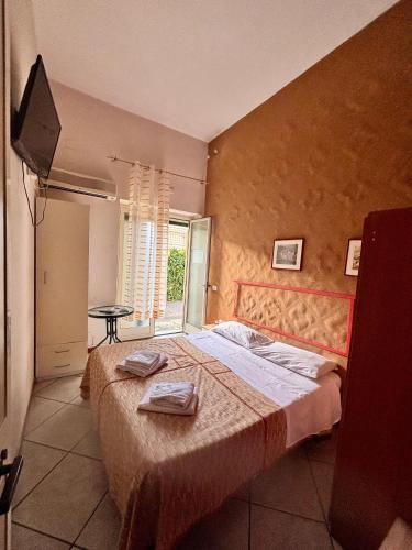 a bedroom with a large bed and a television at Guest house in Acireale in Santa Tecla