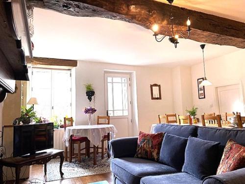 a living room with a blue couch and a table at Chez Providence Chambres et Table d'Hôtes in Cuxac-Cabardès