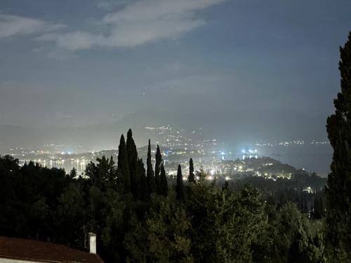 a view of a city at night with trees at Athinas House in Corfu Town